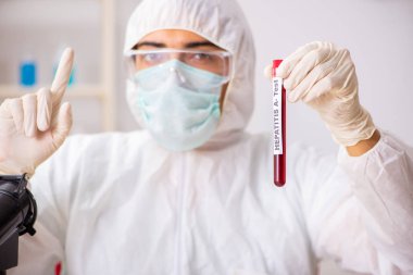 Genç yakışıklı laboratuvar asistanı hastanede kan örnekleri test ediyor. 