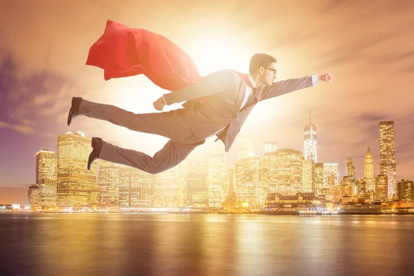 Superhero businessman flying over the city