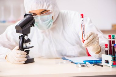 Genç yakışıklı laboratuvar asistanı hastanede kan örnekleri test ediyor. 