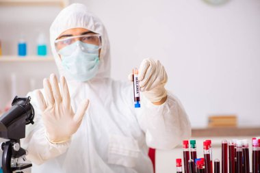 Genç yakışıklı laboratuvar asistanı hastanede kan örnekleri test ediyor. 