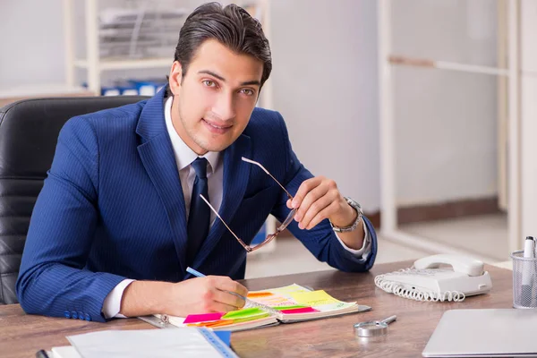 Jovem e bonito funcionário planejando sua atividade laboral — Fotografia de Stock