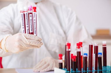 Genç yakışıklı laboratuvar asistanı hastanede kan örnekleri test ediyor. 