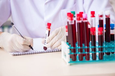 Genç yakışıklı laboratuvar asistanı hastanede kan örnekleri test ediyor. 