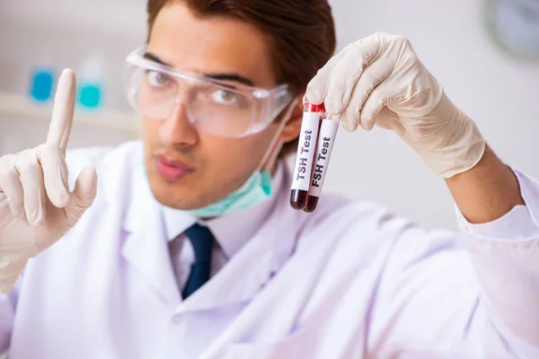 Молодий красивий лабораторний асистент тестування зразків крові в лікарні — стокове фото