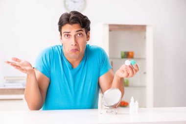 Evde kontak lensleri deneyen adam