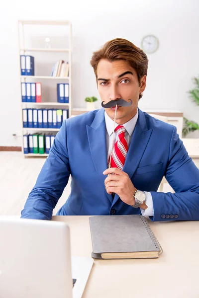 Забавный бизнесмен с фальшивыми усами в офисе — стоковое фото