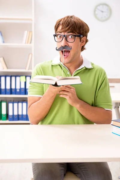 Estudante com bigode falso livro de leitura — Fotografia de Stock