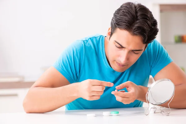 Homem tentando lentes de contato em casa — Fotografia de Stock