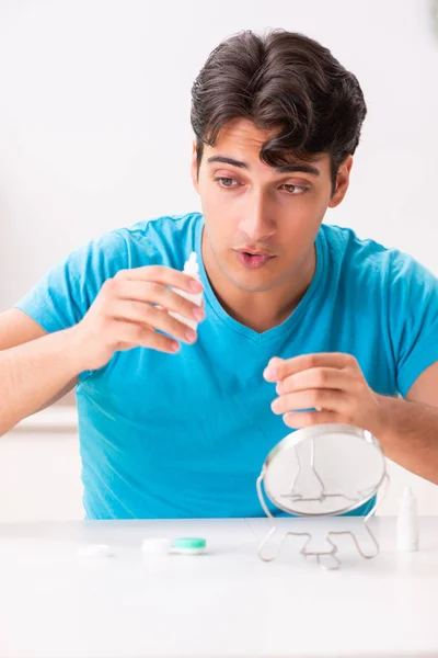 Homem tentando lentes de contato em casa — Fotografia de Stock