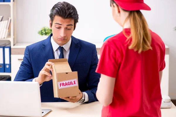 Courier delivering parcel to the office — Stock Photo, Image