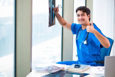Hastanede çalışan yakışıklı genç bir doktor. 