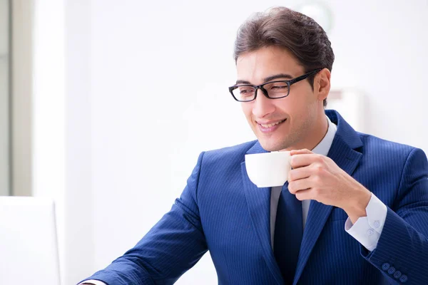 Joven hombre de negocios guapo tomando café en la oficina — Foto de Stock
