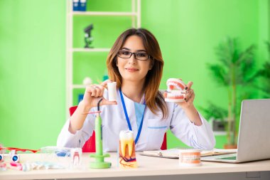 Diş implantı üzerinde çalışan kadın dişçi.