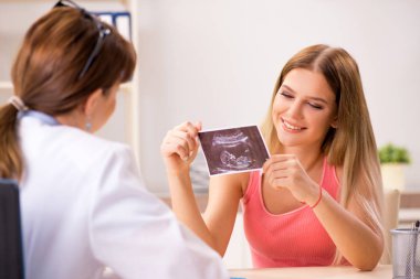 Güzel hamile kadın, kadın jinekoloğu ziyaret ediyor.  