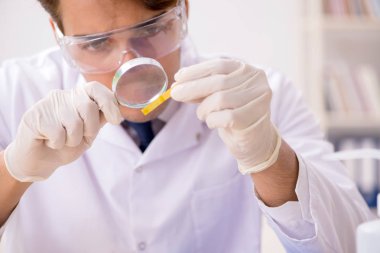 Laboratuvardaki kimyager ph bantlarıyla kontrol ediyor.
