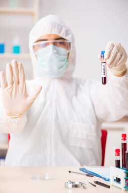 Genç yakışıklı laboratuvar asistanı hastanede kan örnekleri test ediyor. 