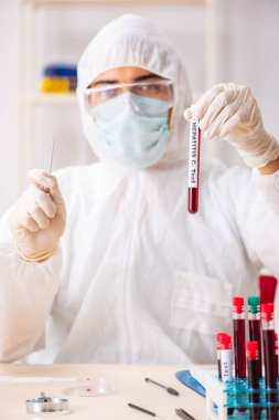 Genç yakışıklı laboratuvar asistanı hastanede kan örnekleri test ediyor. 