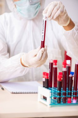 Genç yakışıklı laboratuvar asistanı hastanede kan örnekleri test ediyor. 