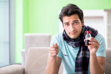 Evde hastalıktan muzdarip genç yakışıklı bir adam. 