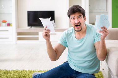 Genç adam kişisel finans ve faturalarla boğuşuyor.