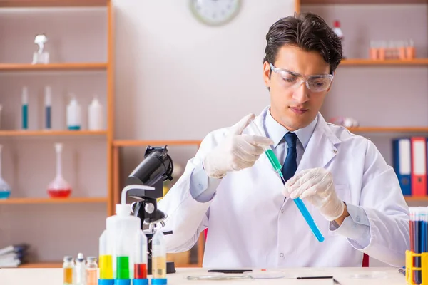 Joven bioquímico guapo trabajando en el laboratorio — Foto de Stock