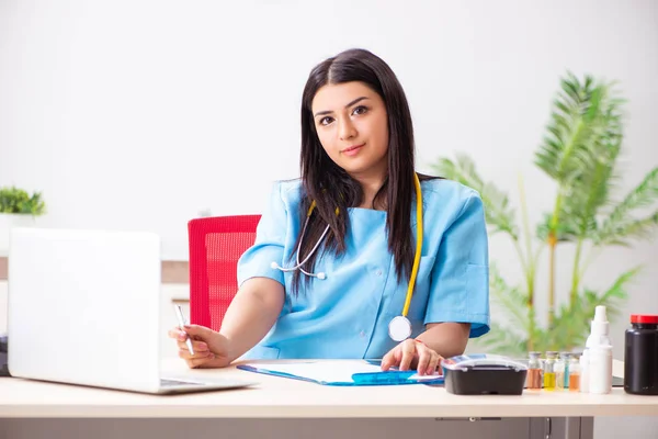 Jonge mooie vrouwelijke arts werkzaam in de kliniek — Stockfoto