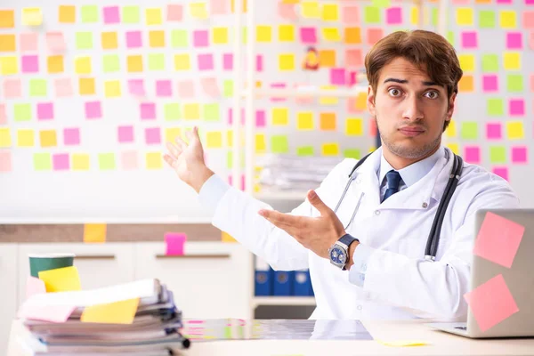 Male doctor with many conflicting prioritites — Stock Photo, Image