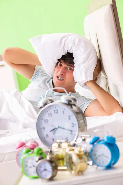 Young man having trouble waking up in early morning