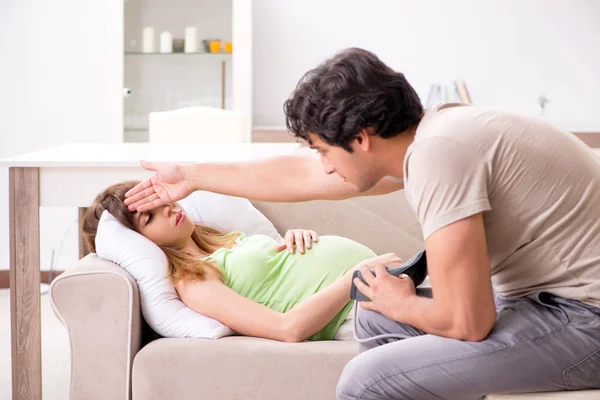 Manžel kontroluje těhotné ženy krevní tlak — Stock fotografie