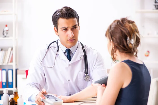 Jonge dokter controleert de bloeddruk van vrouwen — Stockfoto