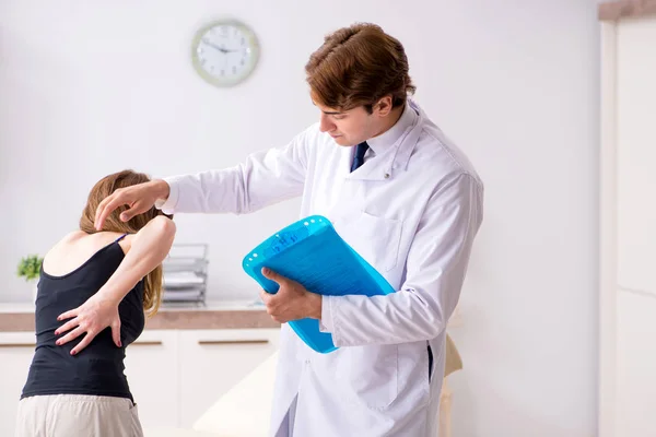 Γυναίκα ασθενής επισκέπτεται νεαρό όμορφο γιατρό χειροπρακτικός — Φωτογραφία Αρχείου