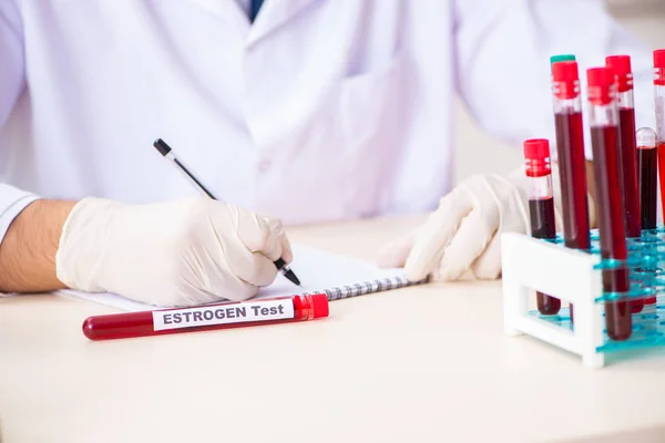 Asistente de laboratorio joven guapo analizando muestras de sangre en el hospital —  Fotos de Stock