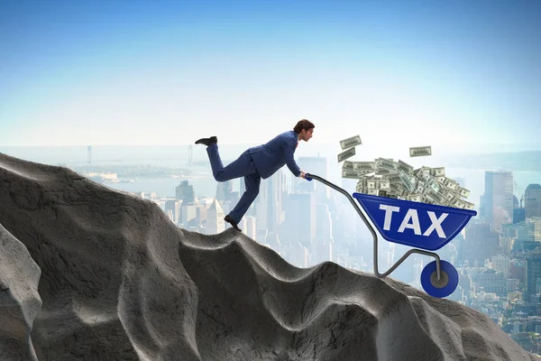 Biznesmen pchanie taczki z pieniędzy podatkowych — Zdjęcie stockowe