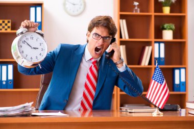 Genç yakışıklı politikacı ofisinde oturuyor. 