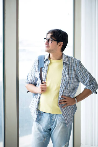 Young handsome student standing at the window — Stock Photo, Image