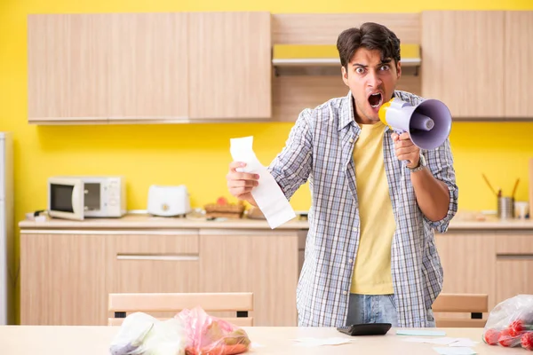 Jeune homme calcul des dépenses pour les légumes dans la cuisine — Photo