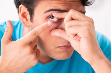 Evde kontak lensleri deneyen adam