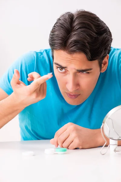 Hombre tratando de lentes de contacto en casa — Foto de Stock