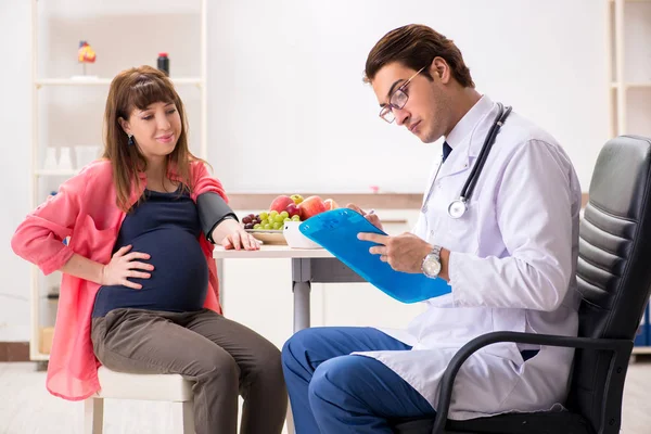 Pregnant woman visiting doctor discussing healthy diet — Stock Photo, Image