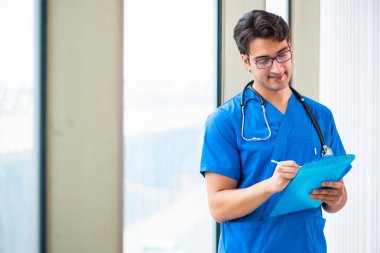 Hastanede çalışan yakışıklı genç bir doktor. 