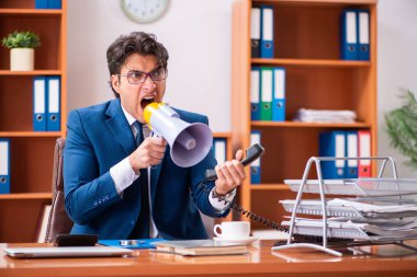 Genç yakışıklı işadamı ofiste çalışıyor.