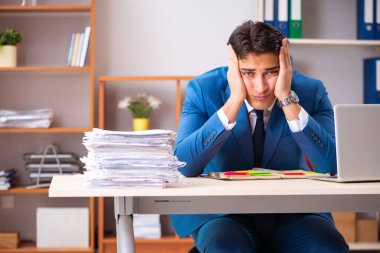 Genç yakışıklı işadamı ofiste çalışıyor. 