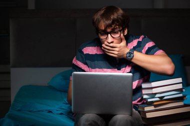 Geceleri sınava hazırlanan yakışıklı bir genç.