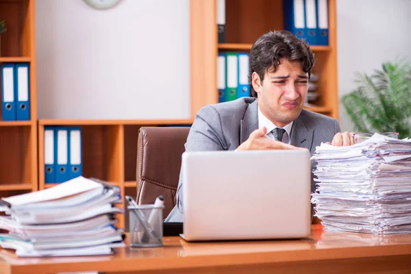 Young handsome businessman unhappy with excessive work — Stock Photo, Image