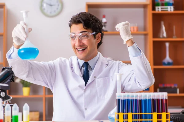 Mladý pohledný biochemik pracující v laboratoři — Stock fotografie