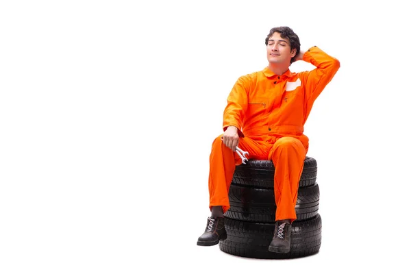 Young garage worker with tyre isolated on white — Stock Photo, Image