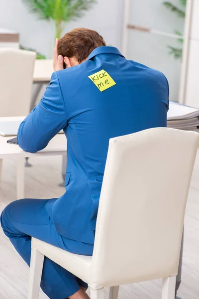 Office prank with kick me message on sticky note