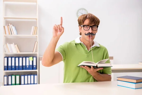 Student mit falschem Schnauzbart liest Buch — Stockfoto