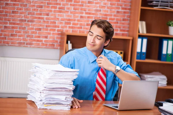 Young employee with excessive work sitting at the office — Stock Photo, Image