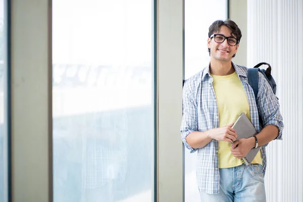 Joven estudiante guapo de pie en la ventana — Foto de Stock